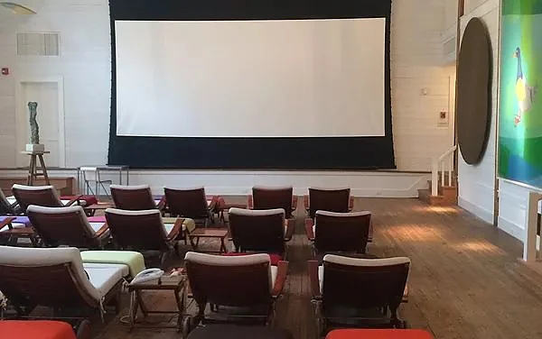 Large screening room in East Hampton with tiered seating facing a cinema screen