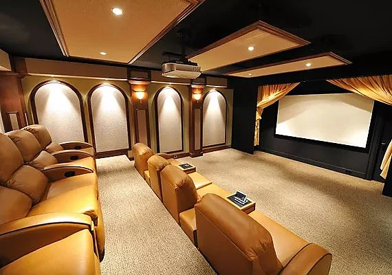 Dedicated home theater with tiered leather seating facing a large screen